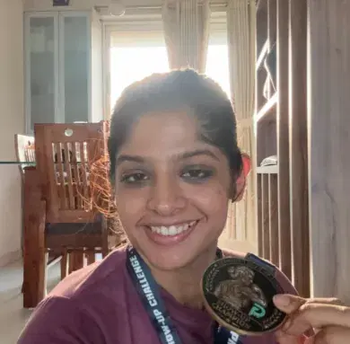 Suvidha smiling, holding up her Show-Up Champion medal with its lanyard around her neck.