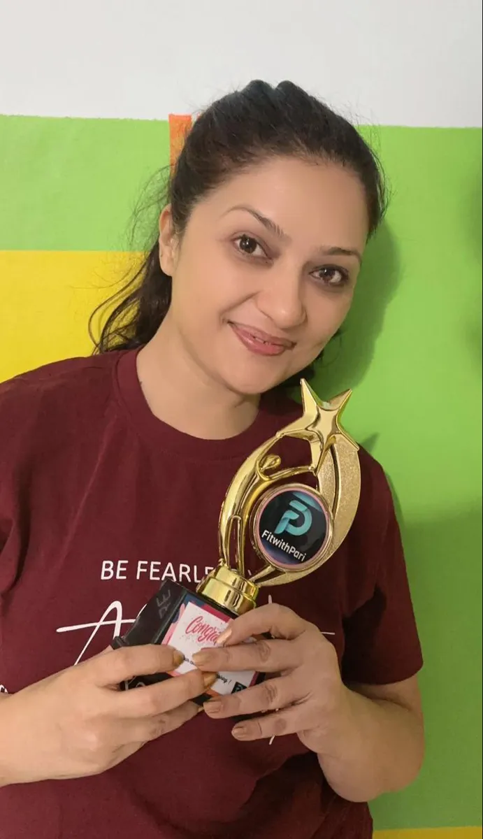 FitwithPari member holding an earlier recognition trophy