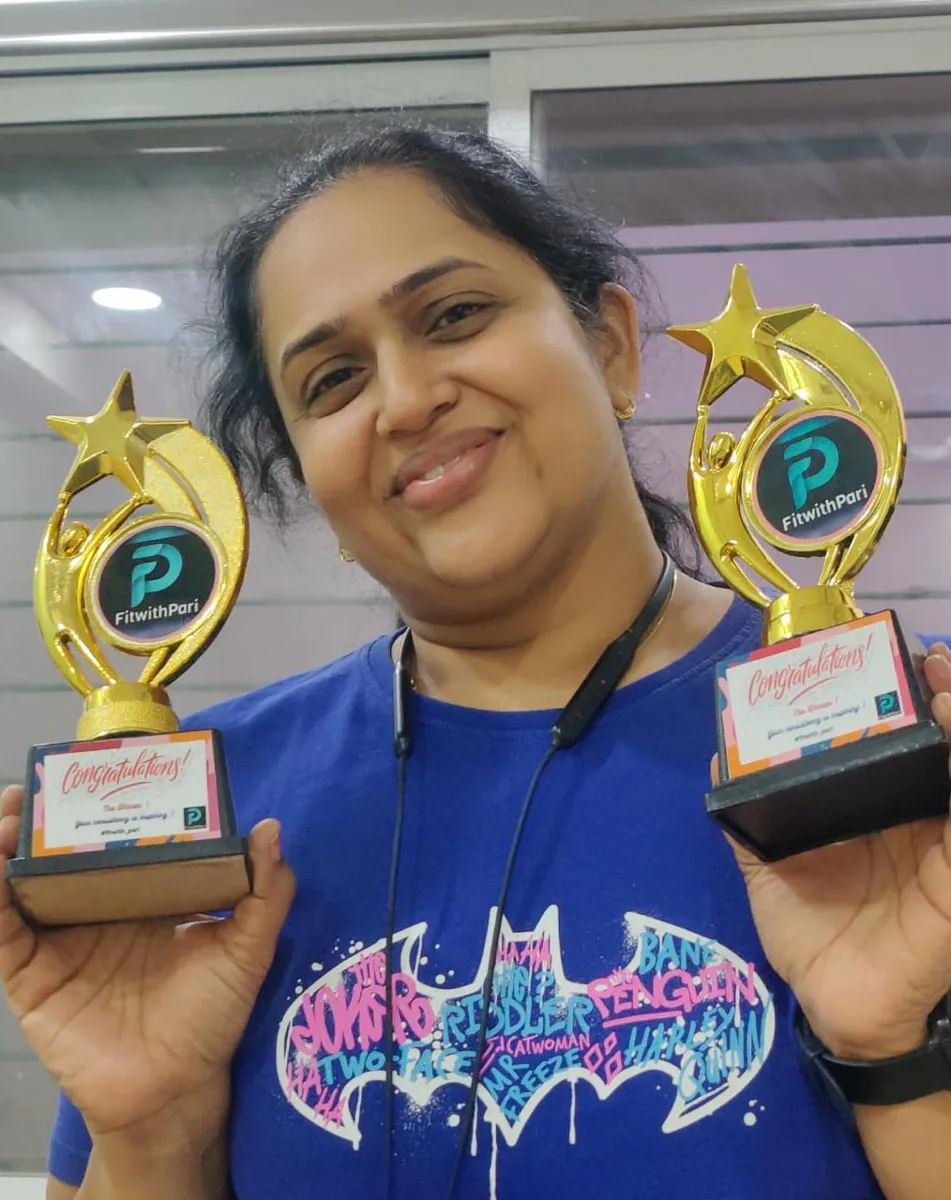 FitwithPari member holding an earlier recognition trophy