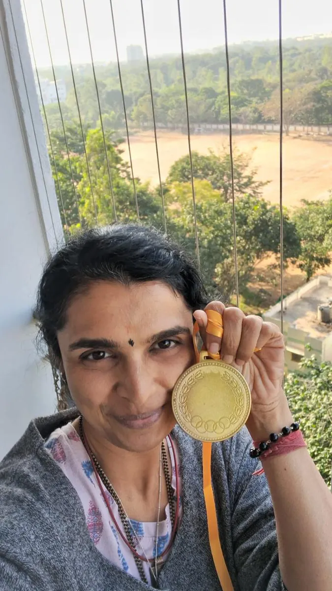 FitwithPari member holding an earlier recognition medal