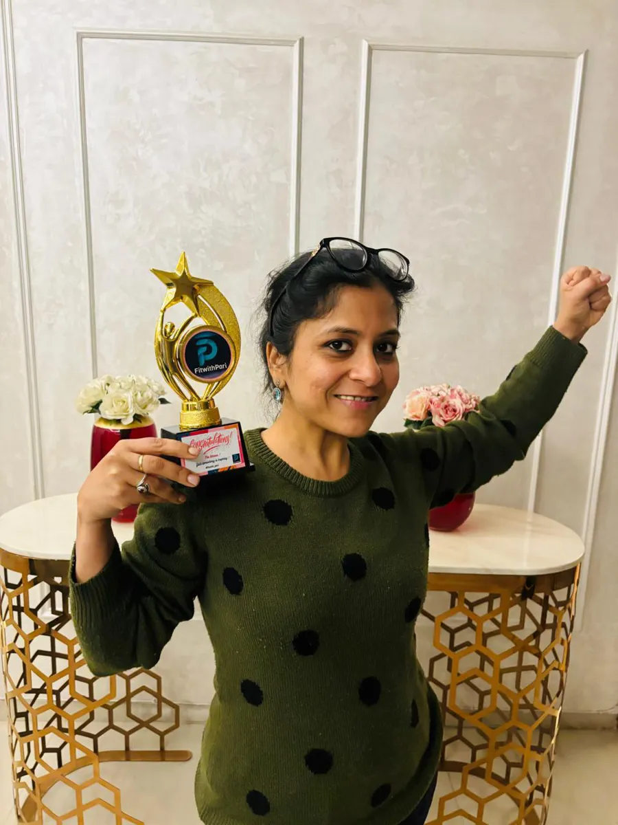 FitwithPari member holding an earlier recognition trophy