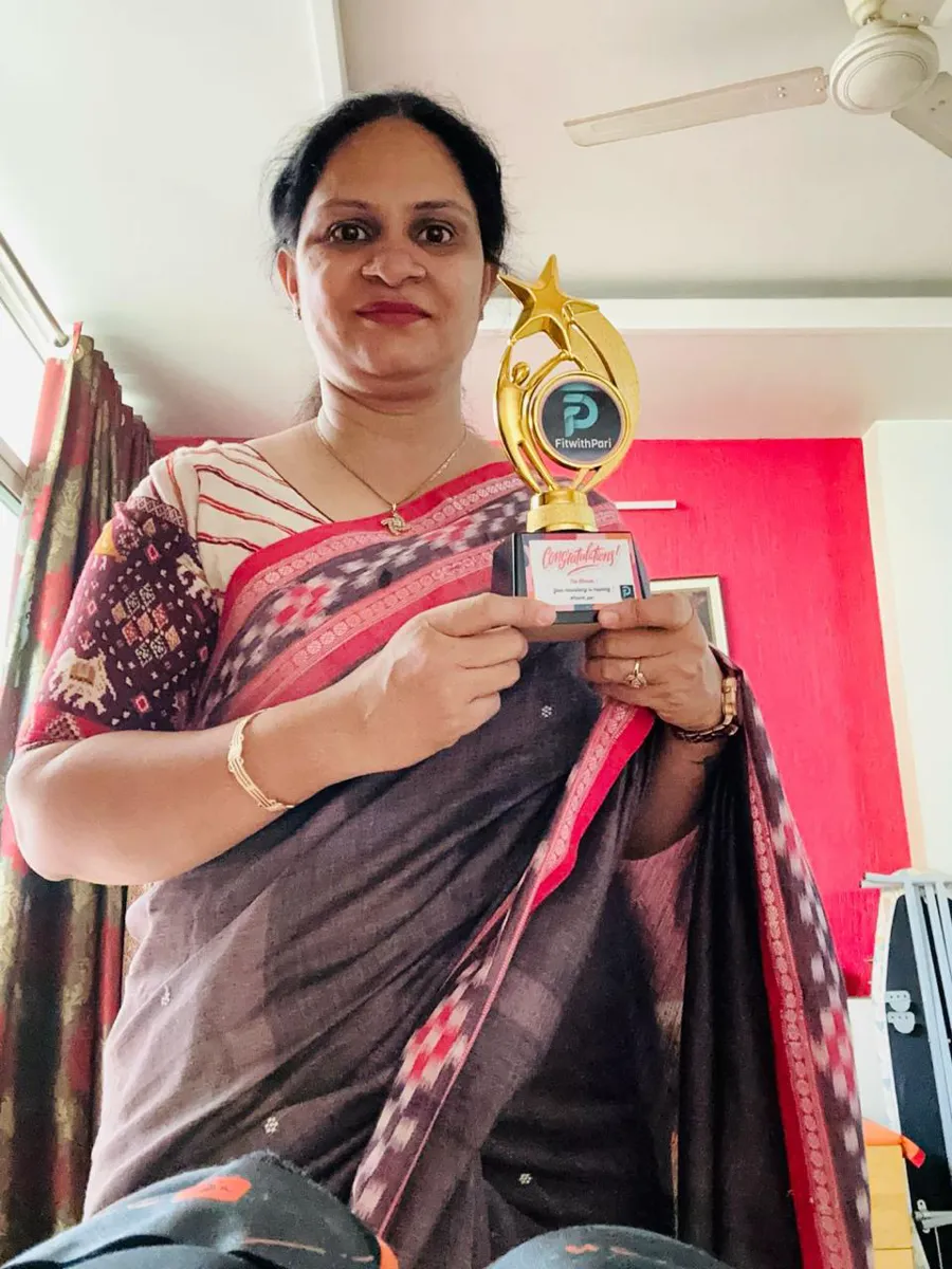FitwithPari member holding an earlier recognition trophy
