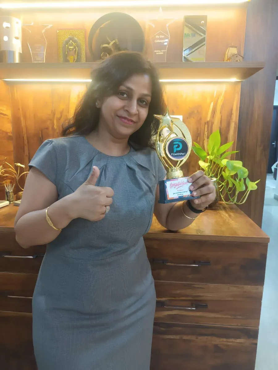 FitwithPari member holding an earlier recognition trophy