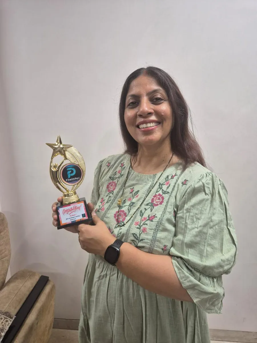FitwithPari member holding an earlier recognition trophy