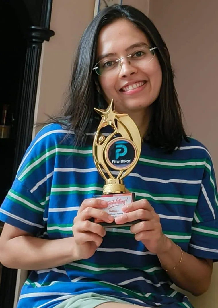 FitwithPari member holding an earlier recognition trophy