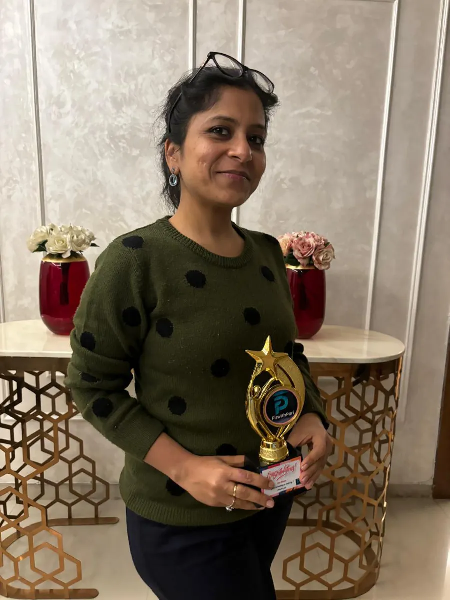 FitwithPari member holding an earlier recognition trophy