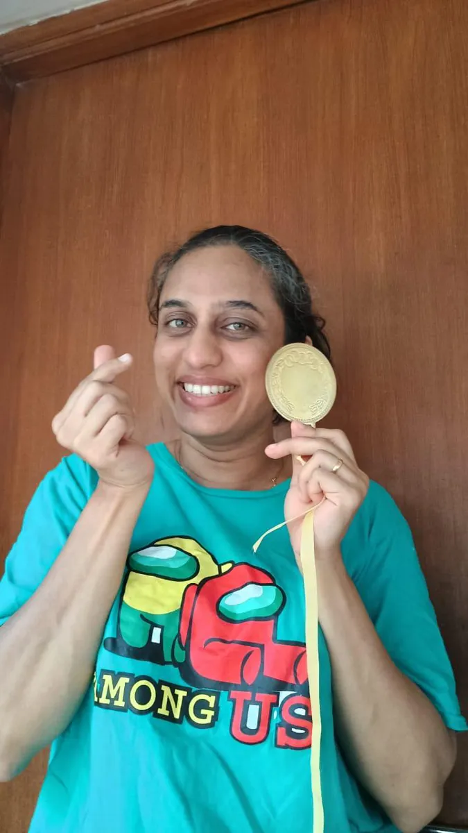 FitwithPari member holding an earlier recognition medal