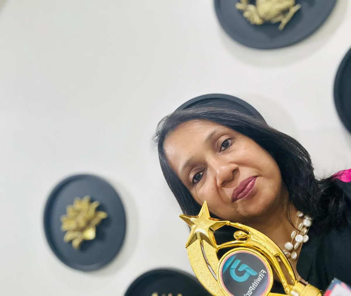 FitwithPari member holding an earlier recognition trophy