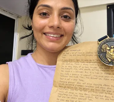 Niharika holding the handwritten letter from Pari in one hand and her Show-Up Champion medal in the other.