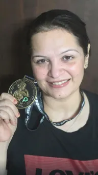 Ramita smiling, holding up her Show-Up Champion medal on its lanyard.